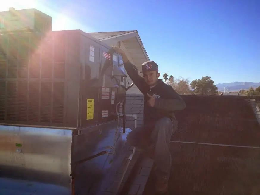 HVAC technician performing Boiler Repair on a rooftop unit in Penitas